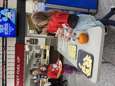Students serving 'lightbulb' cookies during the Lights ON Family Night!
